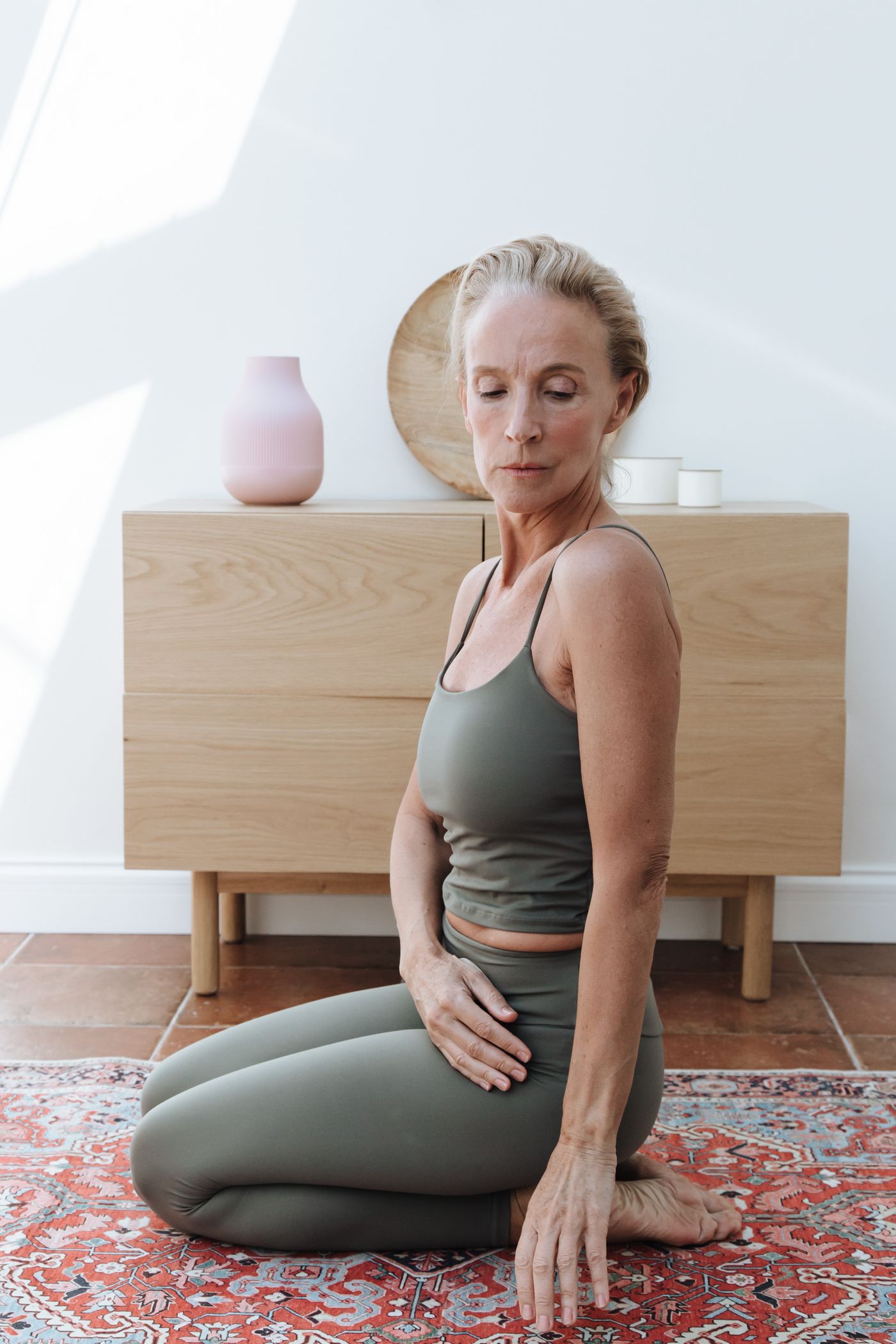 A mature woman practicing yoga indoors.